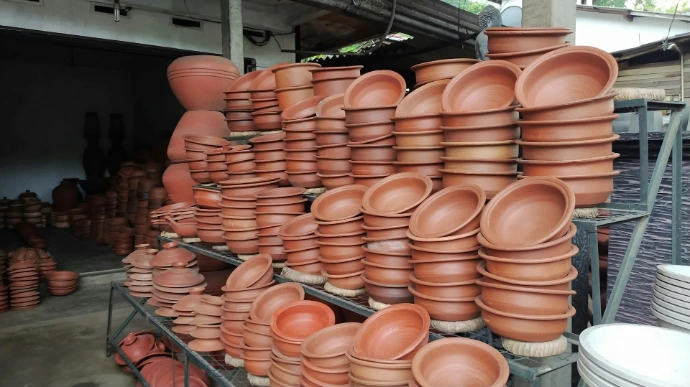 a bunch of clay pots are stacked on a rack